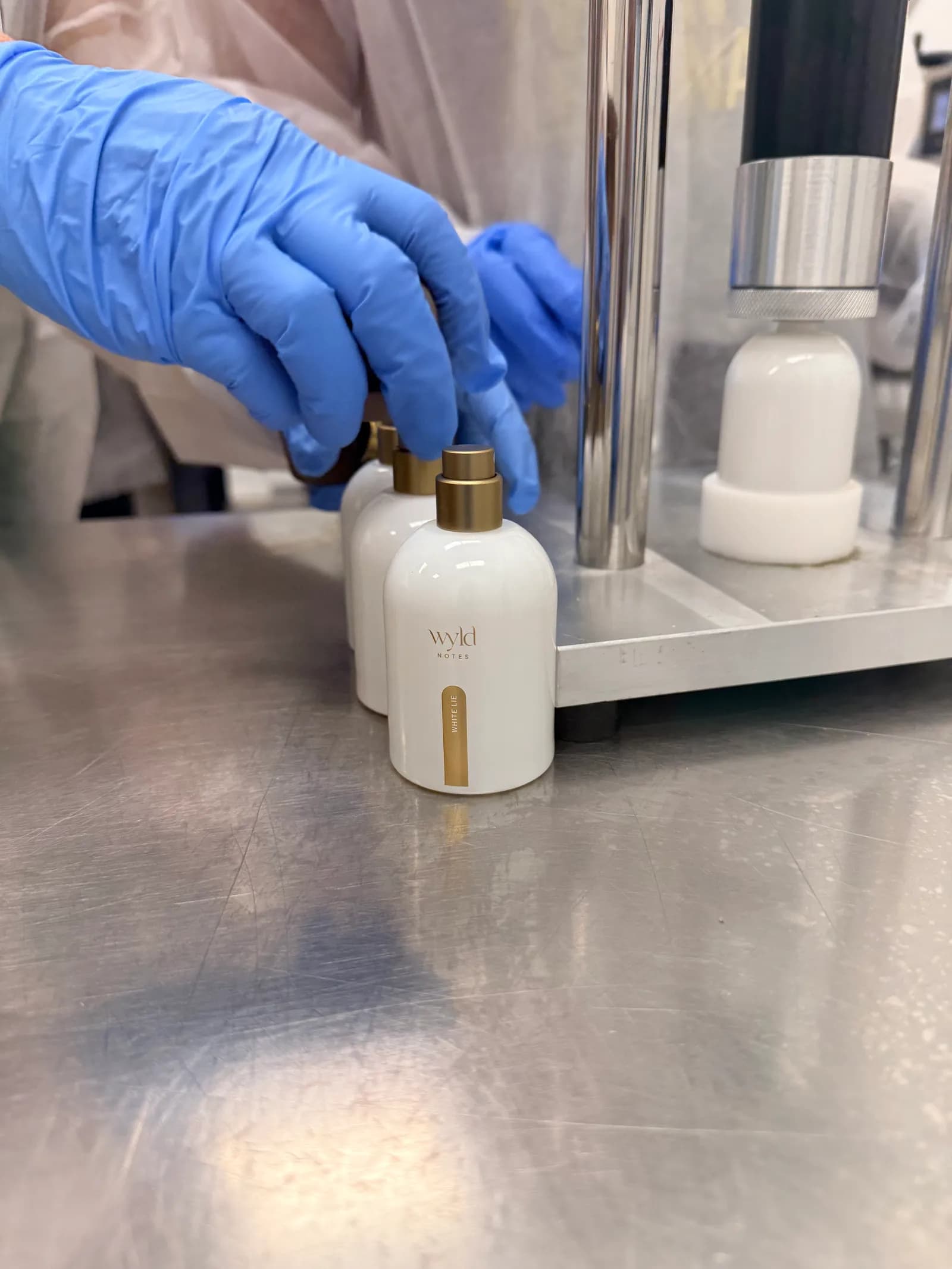 Bottling at Wyld Notes: a white flacon being filled by hand at the line