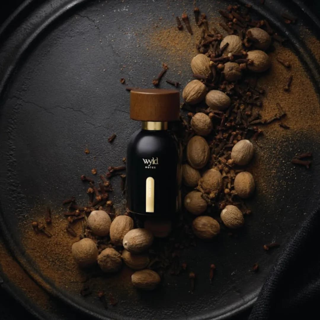 Wyld Notes Black Book on a dark plate among nutmegs and cloves