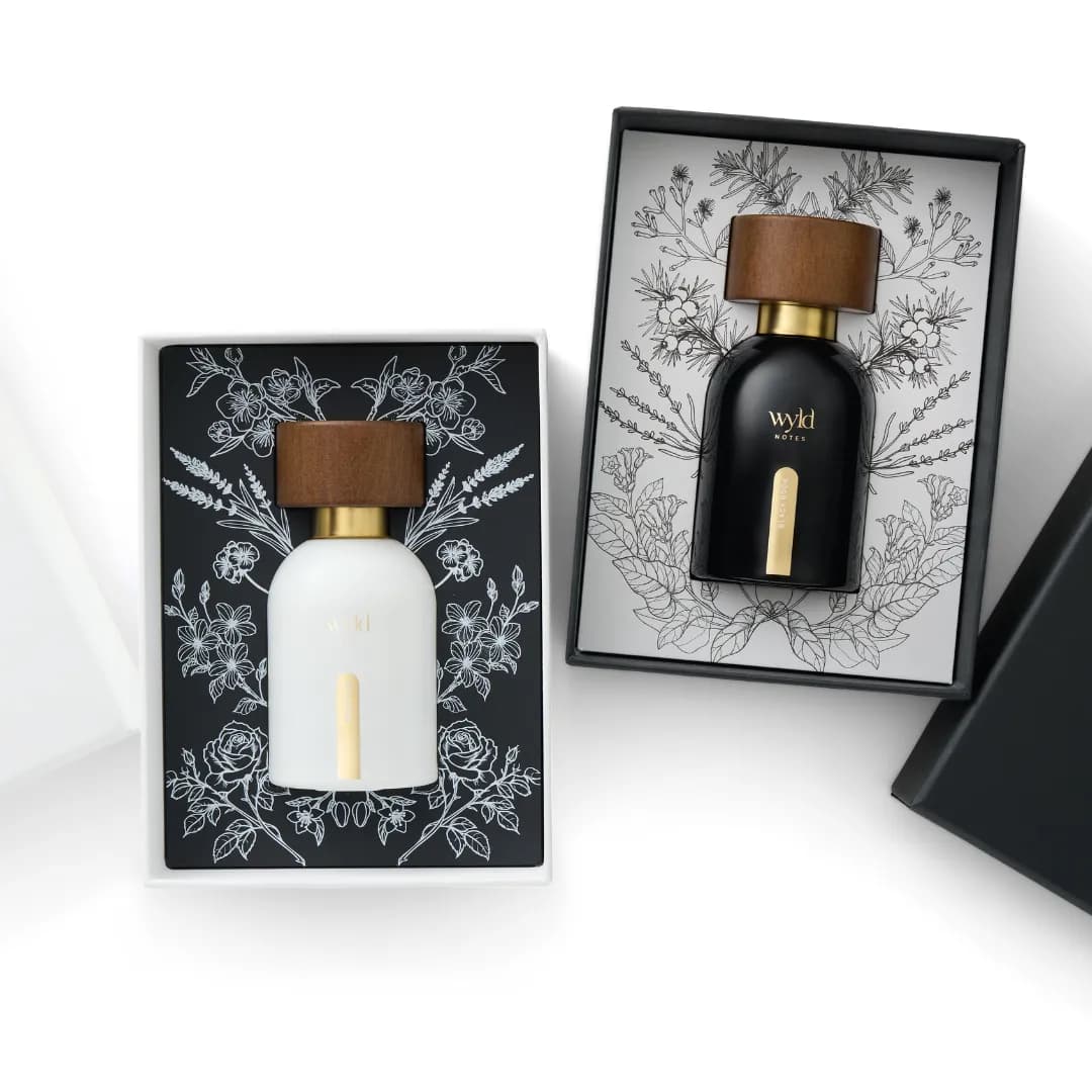 White Lie and Black Book in their gift boxes with botanical illustrations
