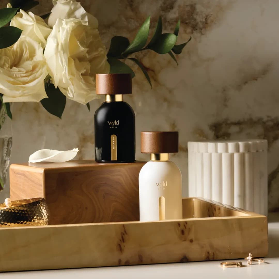 The His & Hers duo: the black and the white bottle on a wooden tray