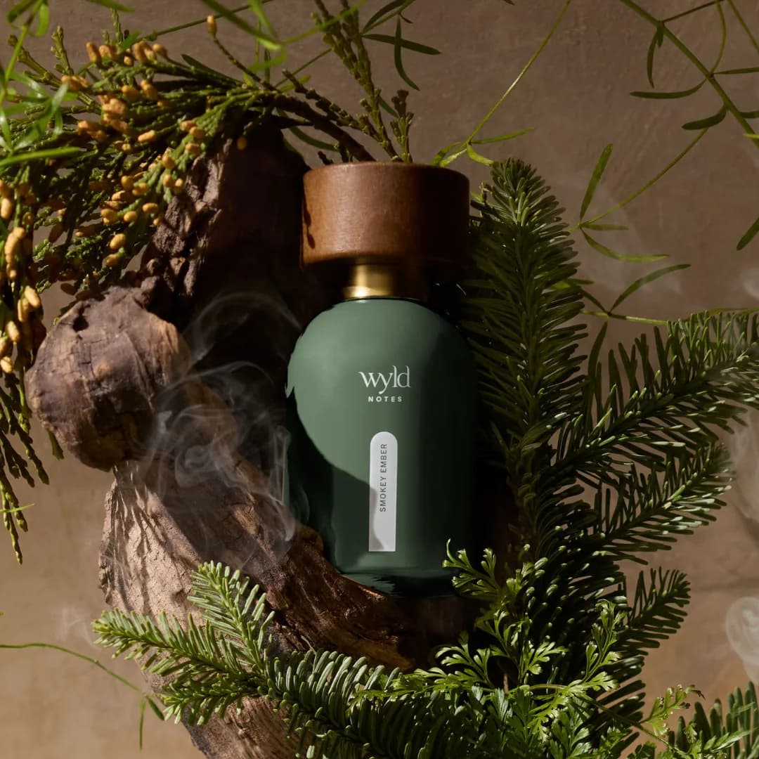 Wyld Notes Smokey Ember among conifer branches with rising smoke